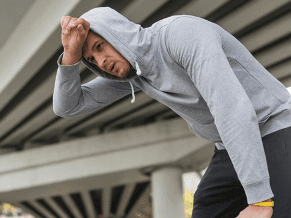 Athlete holding their head after a sports injury highlighting concussion risks in athletics